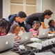 Volunteers work with young girls during a Black Girls Code workshop.
Black Girls Code